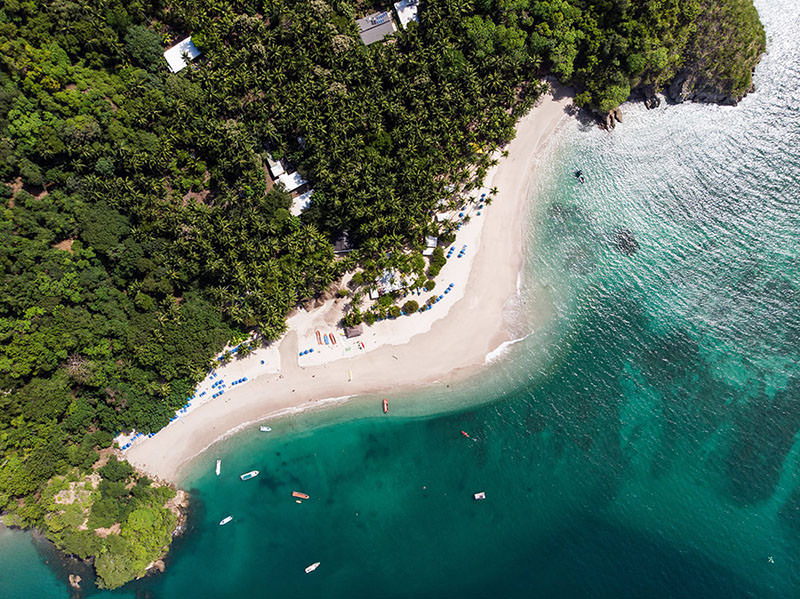 aerial view of a Costa Rican beach showing jungle, sand and greenish-blue water